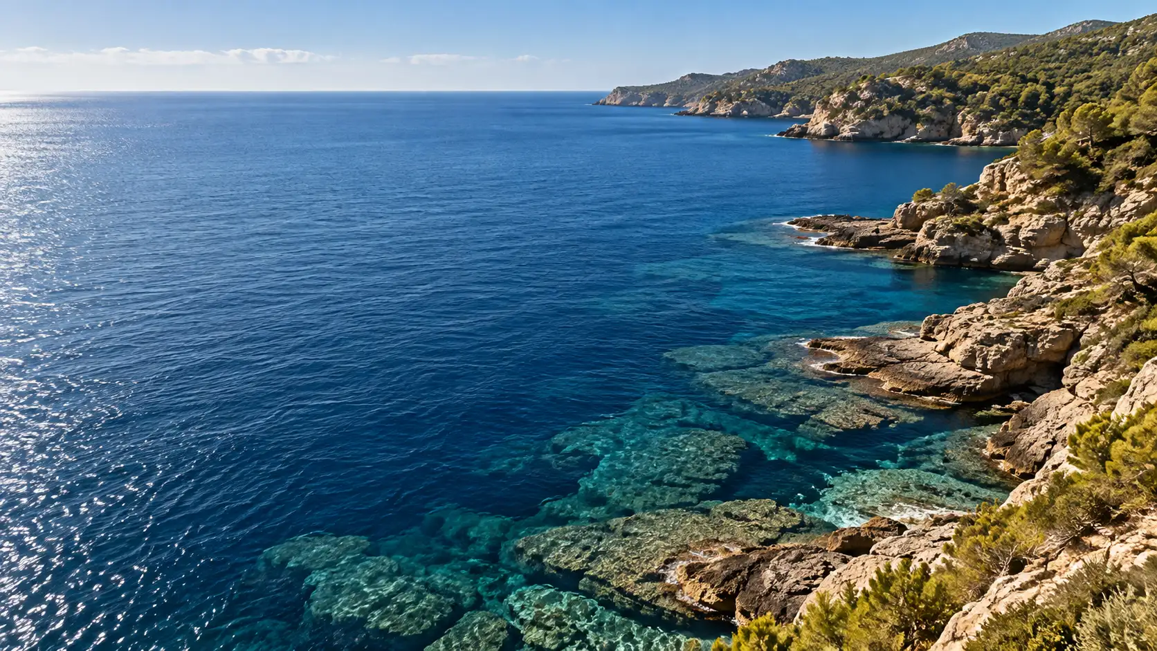 Agua transparente y azul sobre rocas planas, vista desde arriba